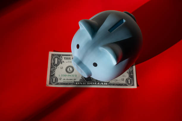 A blue piggy bank and a US $1 bill in a light and shadow composition