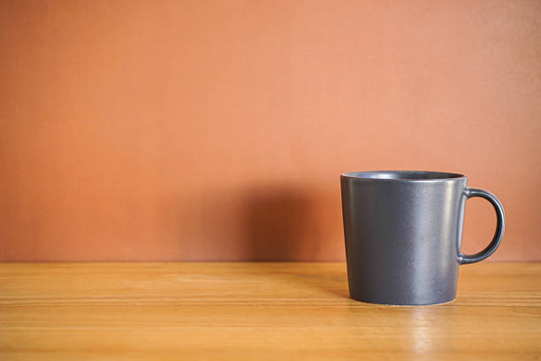 istock Black coffee mug on wood table with brown background 2246364622
