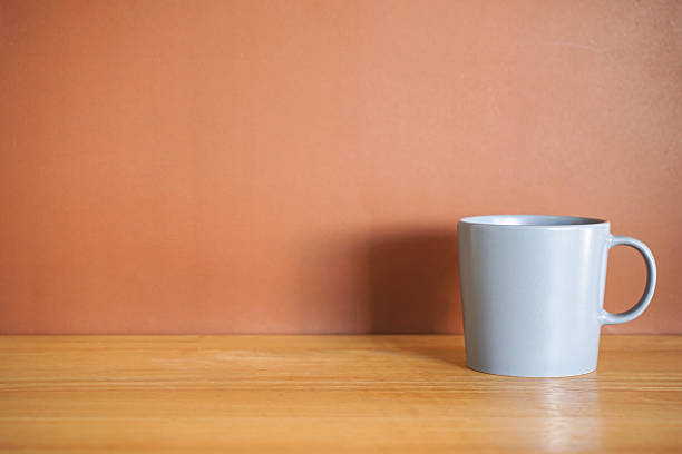 istock Grey coffee mug on wood table with brown background 2246364632