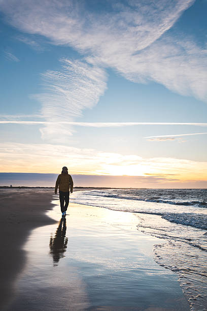 istock Traveler walking along Skagen beach during sunset. Reflective light on wet sand creates a tranquil Nordic scene of solitude and freedom 2246364661