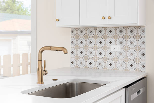istock A gold kitchen faucet detail with a pattern tile backsplash. 2246366544