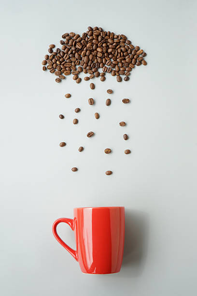 istock Coffee beans arrange with rainy cloud shape and raining to red coffee mug 2246366596