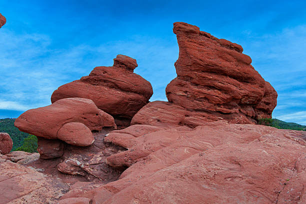 Imposing red rock formations tower against a vibrant blue sky, showcasing natures artistry in a breathtaking landscape.