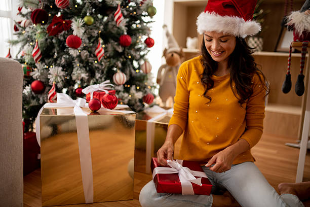 istock Woman tying a bow on a Christmas gift 2246371388