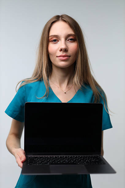 istock Young caucasian female displaying a blank laptop screen 2246371451