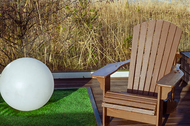 a round illumination sphere and a wooden garden chair, outdoor shot
