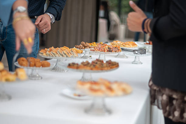 istock Elegant Buffet Spread Showcasing Diverse Appetizers and Savory Bites at a Private Social Gathering with Guests Mingling and Enjoying the Food 2246376231