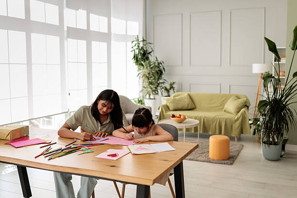 istock Sisters Drawing Together in Bright Living Room 2246380515
