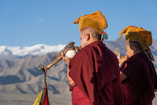 Thiksey, India - September 17, 2025: Two monks blow horns as part of the daily morning ceremony at Thiksey monastery.