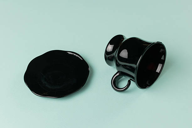 istock Minimalistic Black Tea Cup and Saucer on Light Green Background: Modern Elegance in Stock Photography 2246390373
