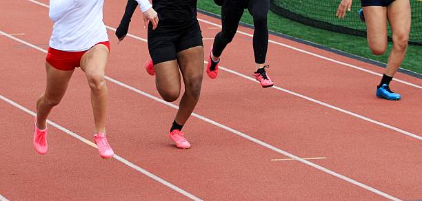istock Four Female Runners Sprinting on Track During a Competitive Race Event 2246390402