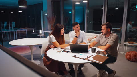 Engaged Team Collaborating on Strategy in Modern Office During Late Night