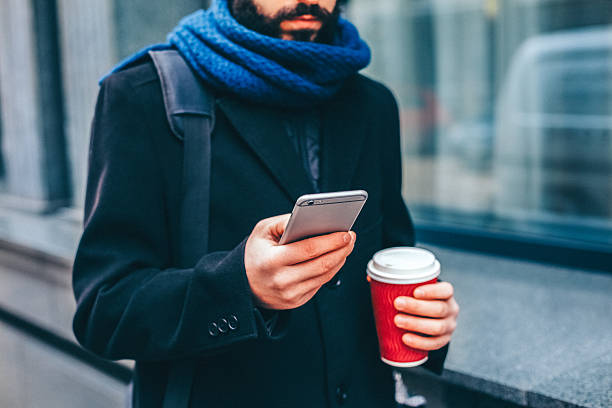 istock Man commuting to work with coffee and smartphone walking through the city. 2246391636