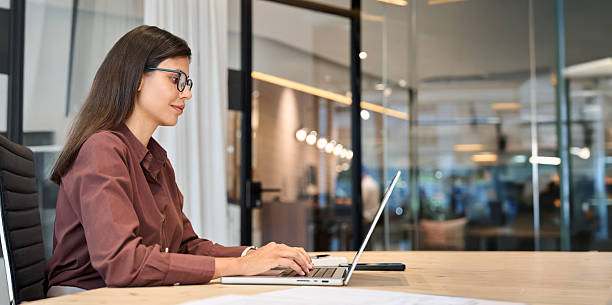istock Young European business woman CEO using laptop application for work at table workspace in office. Mature Latin Hispanic adult professional businesswoman using pc digital computer. Banner, copy space 2246394065