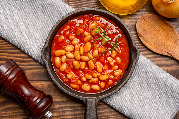 istock Baked bean dish in cast iron pan on wooden background. 2246400894