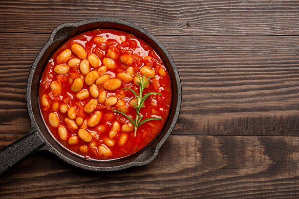 istock Baked bean dish in cast iron pan on wooden background. 2246401407