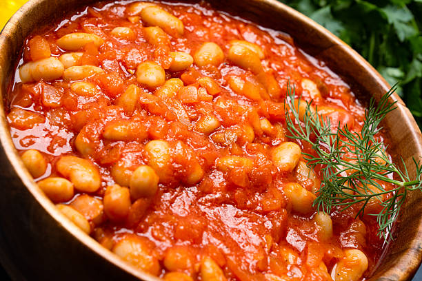 istock Baked bean dish in wooden bowl on black background. 2246401666