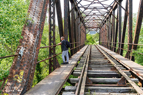 A man stands on an old level crossing on an old iron bridge, Herrera de Duero, Valladolid, Spain.