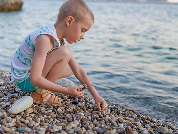 Rear view of a little girl is playing on a beach in the summer