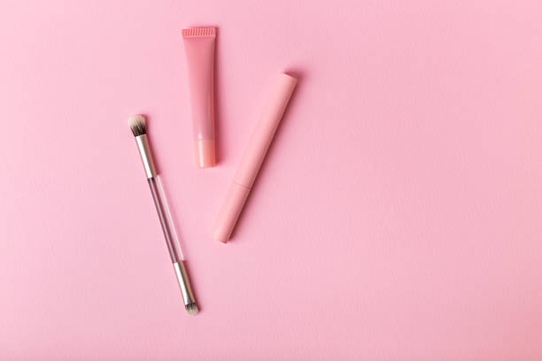 istock Mascara, eyeshadows brush and lip gloss and on pink background. 2246405726