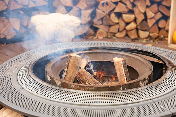istock Cozy outdoor fire pit with logs and smoke rising during a cool evening gathering 2246407792