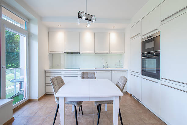 istock Modern Bright Home Kitchen Interior With White Cabinets and Cozy Dining Area 2246408322
