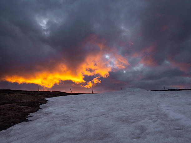 Remnants of snow lit up by sunset clouds at Mount Hotham, Victorian High Country