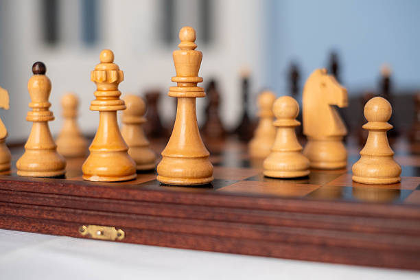 Chess pieces arranged on a wooden chessboard, representing strategy, competition, and intellectual challenge