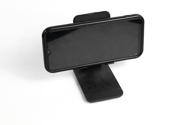 istock smartphone mounted in a black stand holder, isolated on a bright white background. 2246412857
