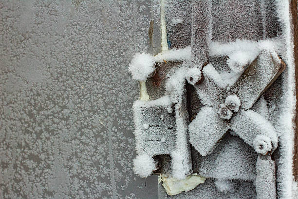 Close-up of a vintage door handle covered in snow and ice, showcasing winter's beauty on a weathered surface, with an interesting texture.