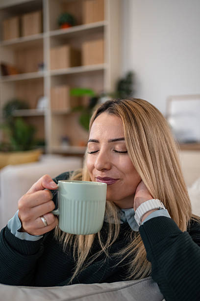 istock Young woman enjoying coffee aroma at home 2246415528