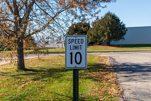 Close-up of a white rectangular American road sign showing a 10 miles per hour speed limit. Classic U.S. traffic regulation sign on a street or parking area, symbol of transportation safety and traffic control. Horizontal photo