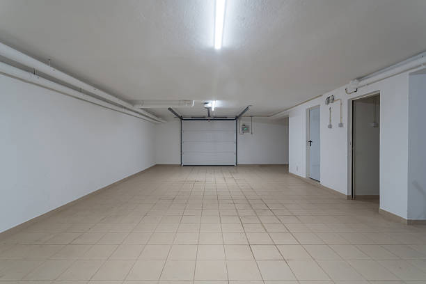 istock This garage features ample space with clean, tiled floors and bright lighting. Ideal for parking vehicles or storing belongings in a residential area 2246418508