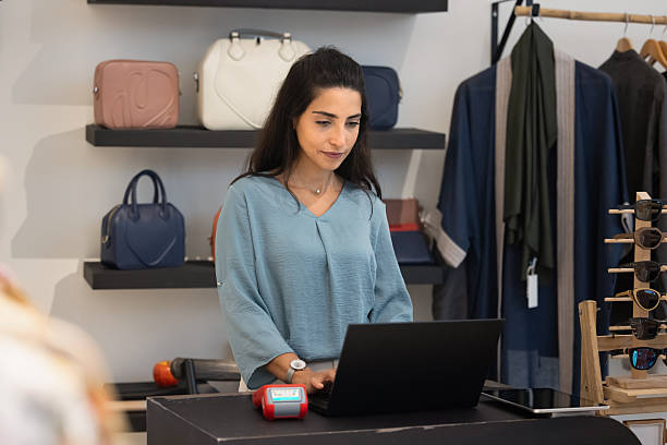 istock Focused busy Hispanic retail store manager woman working at checkout 2246418512