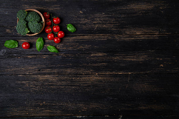 Fresh Broccoli, Cherry Tomatoes and Basil on Dark Rustic Wooden Background