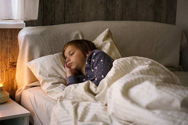 istock Child sleeping peacefully in bed at night 2246421919