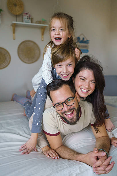 istock Happy family playing together on bed 2246421953