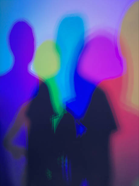 istock People silhouettes blending with colorful neon light blur 2246424459