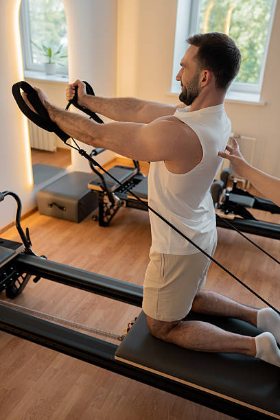 istock Kneeling pulley exercise, practicing on reformer pulley row focusing on shoulder control 2246429429