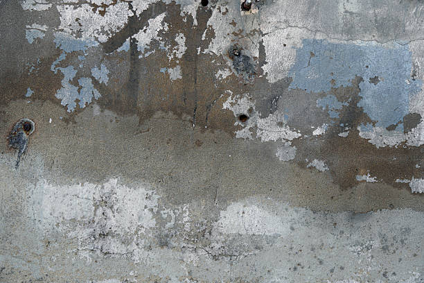 istock Old and weathered concrete wall with a hole and moss growth 2246433266