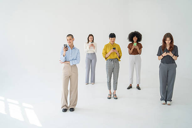 istock Five young businesswomen using their smartphones on white background 2246434633