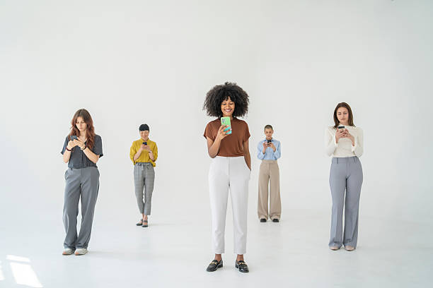 istock Five young businesswomen using their smartphones in a modern office 2246434646