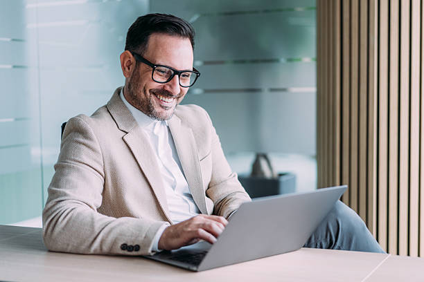 istock Successful businessman in modern office working on laptop. 2246435268