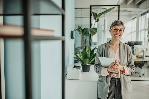 istock Businesswoman in modern office smiling while holding a clipboard during a busy workday 2246437692