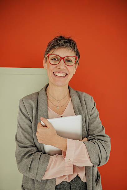 istock Businesswoman smiling confidently in a modern office setting with an orange wall during a successful planning meeting 2246438423