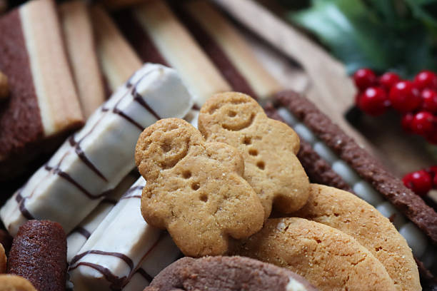 istock Close up image of asssorted luxury cookies / biscuits with Christmas decorations, gingerbread men, Belgian chocolate wafers, focus on foreground 2246438852