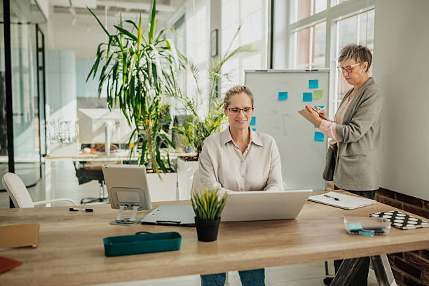 istock Businesswomen collaborating and planning in a modern office space during a productive workday 2246439142