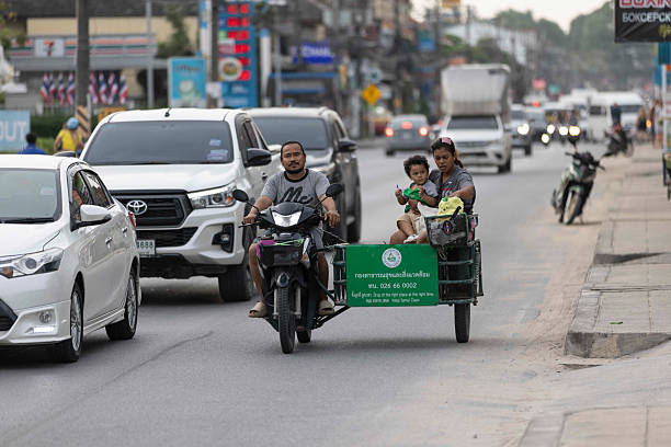 Palembang, Indonesia - April 7, 2025: A bentor (motorized rickshaw) driver stops in front of a motorcycle repair shop to check the condition of his vehicle. This photo depicts the daily life of traditional transportation that still plays an important role in urban areas.