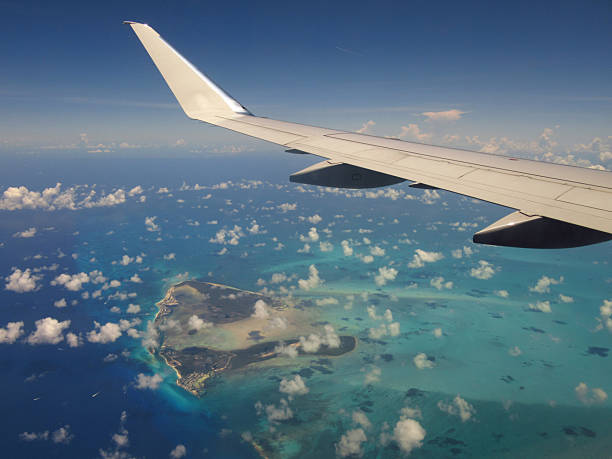 istock Above Caribbean Island with Puffy Clouds Airplane Wing 2246441757
