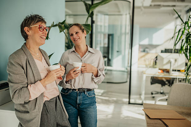 istock Businesswomen enjoying a coffee break while discussing teamwork in a modern office setting 2246442218